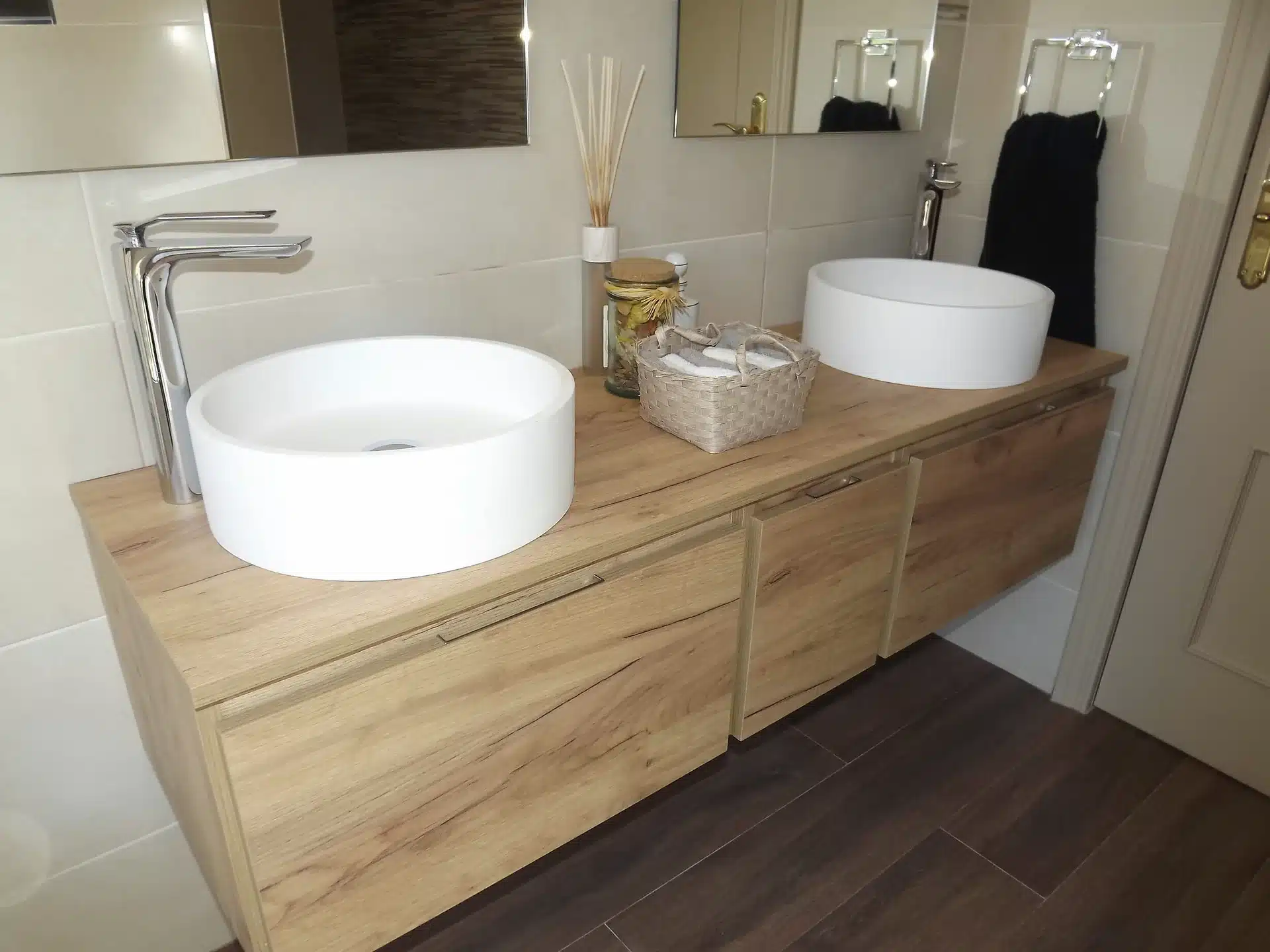 Baño contemporáneo con mueble de roble y dos lavabos sobre encimera, proyecto de Almudena Madrid Interiorismo en Madrid